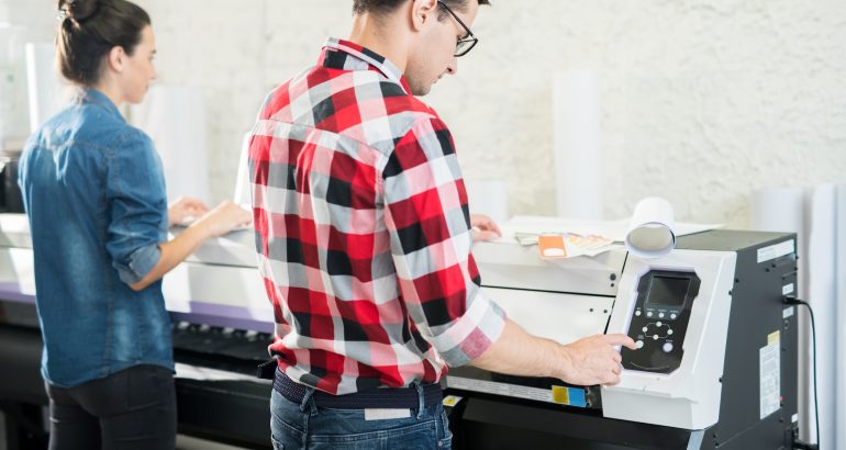 Man and woman using printing equipment
